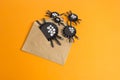 Spiders from paper crawl out of the envelope. Orange background.