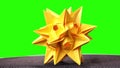 Spiked origami figure of yellow color.