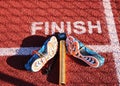 Spikes, baton and stop watch at the finish line on a track Royalty Free Stock Photo