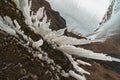 Spiky, icy stalagmites created from the roof of a mountain next to the Kvernufoss waterfall, seen from a vantage point as if it