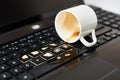 Spill coffee from white cup on the computer laptop keyboard.Damage to computer due to spilled liquid Royalty Free Stock Photo