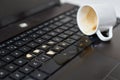 Spill coffee from white cup on the computer laptop keyboard.Damage to computer due to spilled liquid Royalty Free Stock Photo