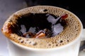 Spilled black coffee in a cup on a black table. Bad surface of the drink in the container Royalty Free Stock Photo