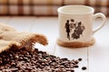 Spilled coffee beans from canvas sack and porcellaneous mug Royalty Free Stock Photo