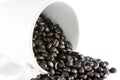 Spilled coffee beans on white ceramic cup Royalty Free Stock Photo