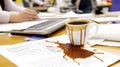 Spilled coffee cup creating stain on important documents at office Royalty Free Stock Photo