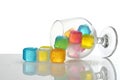 Spilled colored plastic ice cubes in brandy glass Royalty Free Stock Photo