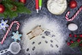spilled flour with traces of toy sleigh on black textured table with christmas tree, red christmas balls, candy canes Royalty Free Stock Photo