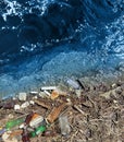Spilled garbage on the beach of the big city. Empty used dirty plastic bottles. Dirty sea. Environmental pollution. Royalty Free Stock Photo