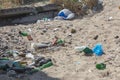 Spilled garbage on beach of big city. Empty used dirty plastic bottles. Dirty sea sandy shore Black Sea. Environmental pollution. Royalty Free Stock Photo