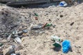 Spilled garbage on beach of big city. Empty used dirty plastic bottles. Dirty sea sandy shore Black Sea. Environmental pollution. Royalty Free Stock Photo