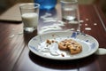 spilled glass of milk beside a plate of chocolate chip cookies Royalty Free Stock Photo