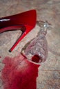 A spilled glass of wine and women`s shoes on the floor