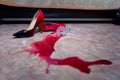 A spilled glass of wine and women`s shoes on the floor