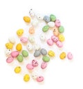 Spilled multicolored quail eggs or small painted chocolate eggs on a white background. Royalty Free Stock Photo