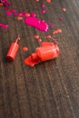 spilled orange nail polish on a wooden background. Drops of nuclear orange varnish on a wooden board.