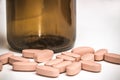 Spilled pink pills from open prescription medication glass bottle Royalty Free Stock Photo