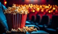 Spilled popcorn bucket on cinema seat with dramatic lighting in an empty movie theater, capturing the atmosphere of Royalty Free Stock Photo