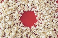 Spilled popcorn on a red background, cinema, movies and entertainment concept