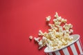 Spilled popcorn on a red background cinema movies and entertainment concept