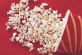 Spilled popcorn on a red background, cinema, movies and entertainment concept