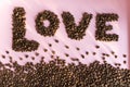 Spilled roasted coffee beans with a love inscription.
