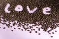 Spilled roasted coffee beans with a love inscription.
