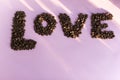 Spilled roasted coffee beans with a love inscription.