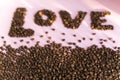 Spilled roasted coffee beans with a love inscription.