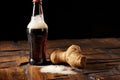 a spilled root beer next to its knocked over bottle