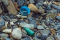 Spilled vivid multi colour garbage on stones background. Close up big plastic bottle. Environmental total pollution