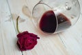 spilled wine from a glass next to a red rose, selective focus Royalty Free Stock Photo