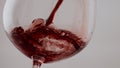 Spilling red wine glass goblet close up. Cabernet pouring splashing in wineglass Royalty Free Stock Photo