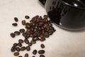 Spilt coffee beans beside a black mug Royalty Free Stock Photo