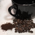 Spilt coffee beans beside a black mug Royalty Free Stock Photo