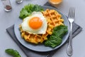 Spinach cheese waffles with fried egg on gray wooden background. Selective focus Royalty Free Stock Photo