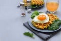 Spinach cheese waffles with fried egg on gray wooden background. Selective focus Royalty Free Stock Photo