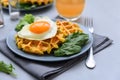 Spinach cheese waffles with fried egg on gray wooden background. Selective focus Royalty Free Stock Photo