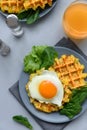 Spinach cheese waffles with fried egg on gray wooden background. Selective focus. Top view Royalty Free Stock Photo