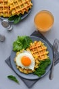 Spinach cheese waffles with fried egg on gray wooden background. Selective focus. Top view Royalty Free Stock Photo