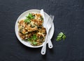 Spinach courgettes fritters - delicious vegetarian snacks, appetizers, breakfast on a dark background