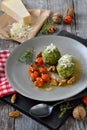 Spinach dumplings with baked tomatoes