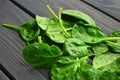 Spinach leaves on dark wooden table background. Vegan food trend. Green living concept