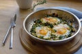 Spinach pan with fried egg and spices, protein-rich vegetarian dish for low carb diet on a rustic wooden board Royalty Free Stock Photo