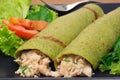 Spinach pancake stuffed with chicken breast and salad in black background