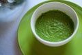 Spinach and pea cream soup served in green bowl, close-up Royalty Free Stock Photo