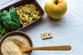 Spinach, pumpkin seeds, sesame, apple and one wood spoon on a white background. microelement FE. Close-up