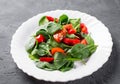 Spinach salad with pepper and tomatoes in white plate Royalty Free Stock Photo