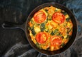 Spinach tomato cheese and hot peppers frittata on a table