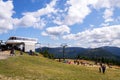 People walk around Medvedin mountain chairlift top station on sunny summer day Royalty Free Stock Photo